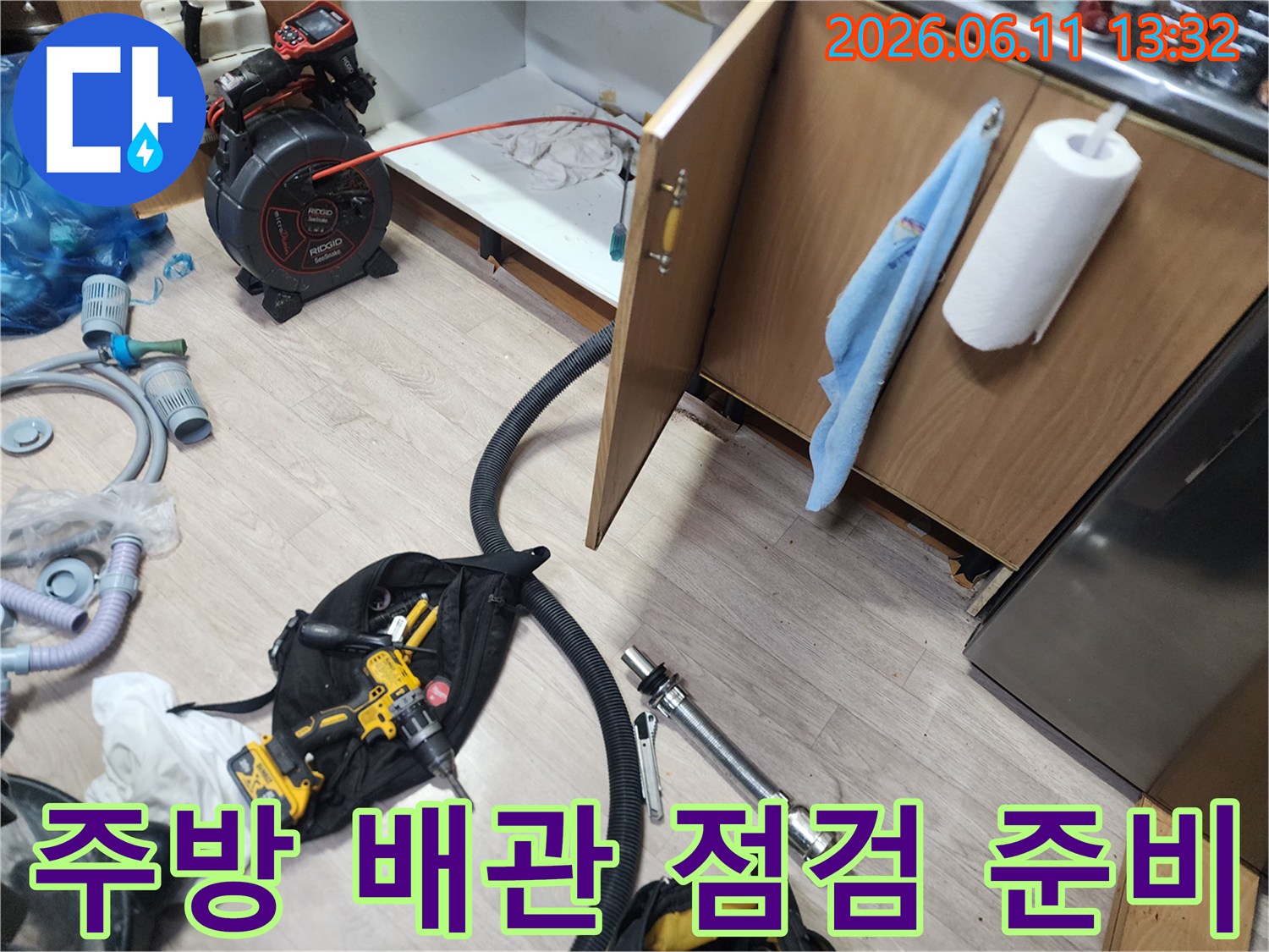 싱크대 하부장 내부의 막힌 배관을 진단하기 위해 장비를 배치한 모습입니다.