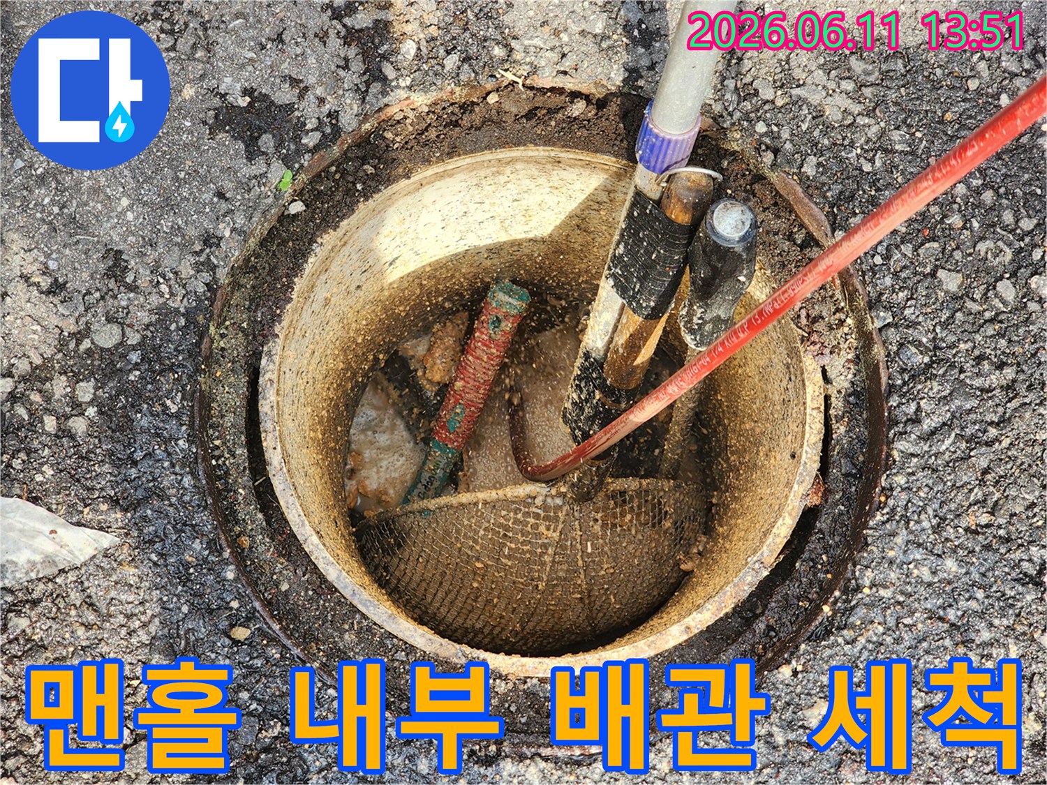 맨홀 내부에 투입된 고압 호스가 배관의 찌꺼기를 제거하고 있습니다.