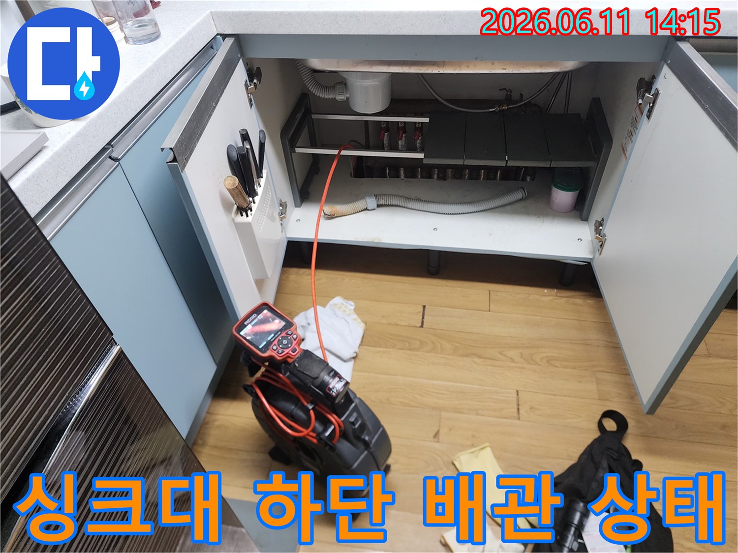 싱크대 아래쪽 연결된 배관과 석션 장비가 놓여 있는 현장 모습입니다.