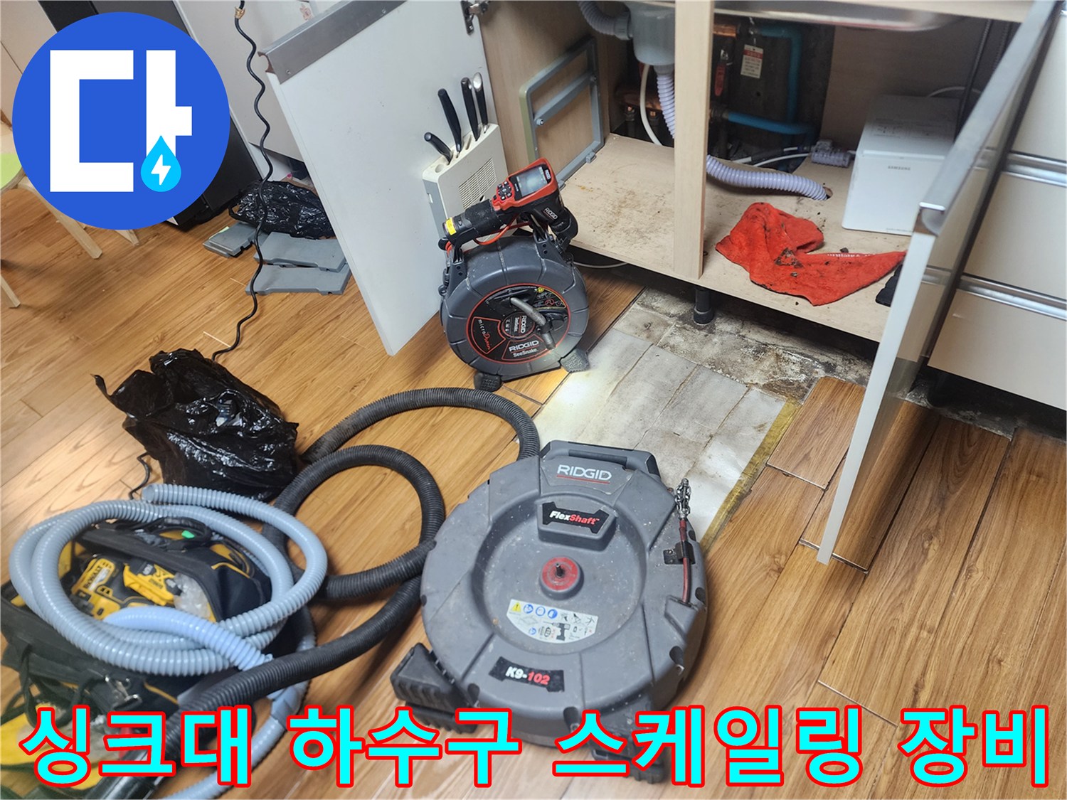 주방 싱크대 아래 배관 작업을 위해 설치된 리지드 플렉스 샤프트와 석션기 장비 모습