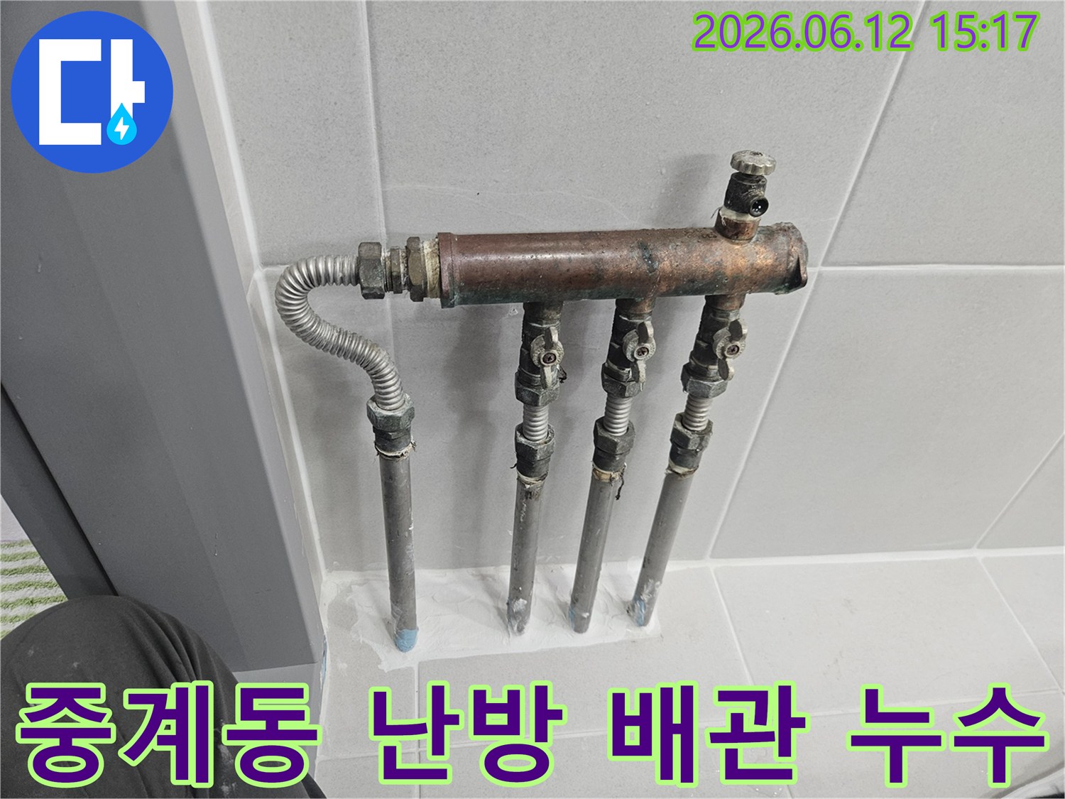 노원구 중계동 빌라의 난방 배관 분배기에서 누수 흔적이 발견되어-전문가가 부식된 배관 연결부를 면밀히 점검하는 중입니다