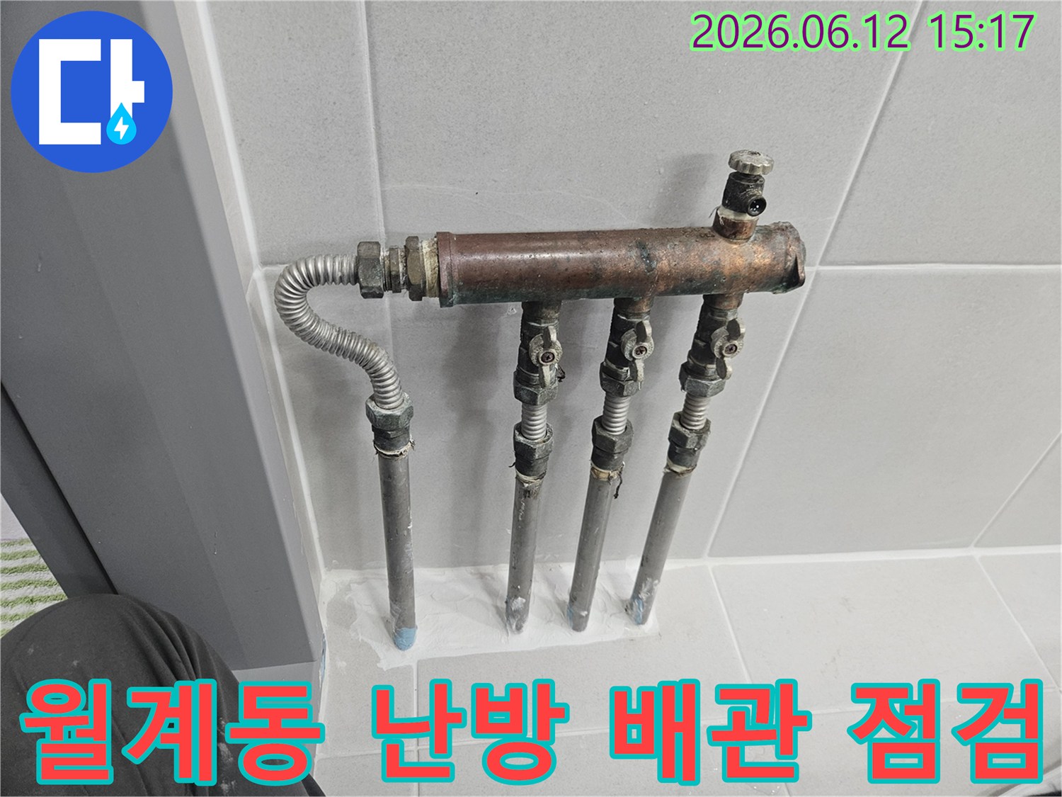 월계동 주택의 난방 배관 분배기에서 누수 징후가 발견되어-전문가가 부식된 배관과 밸브 상태를 꼼꼼히 확인하는 중입니다
