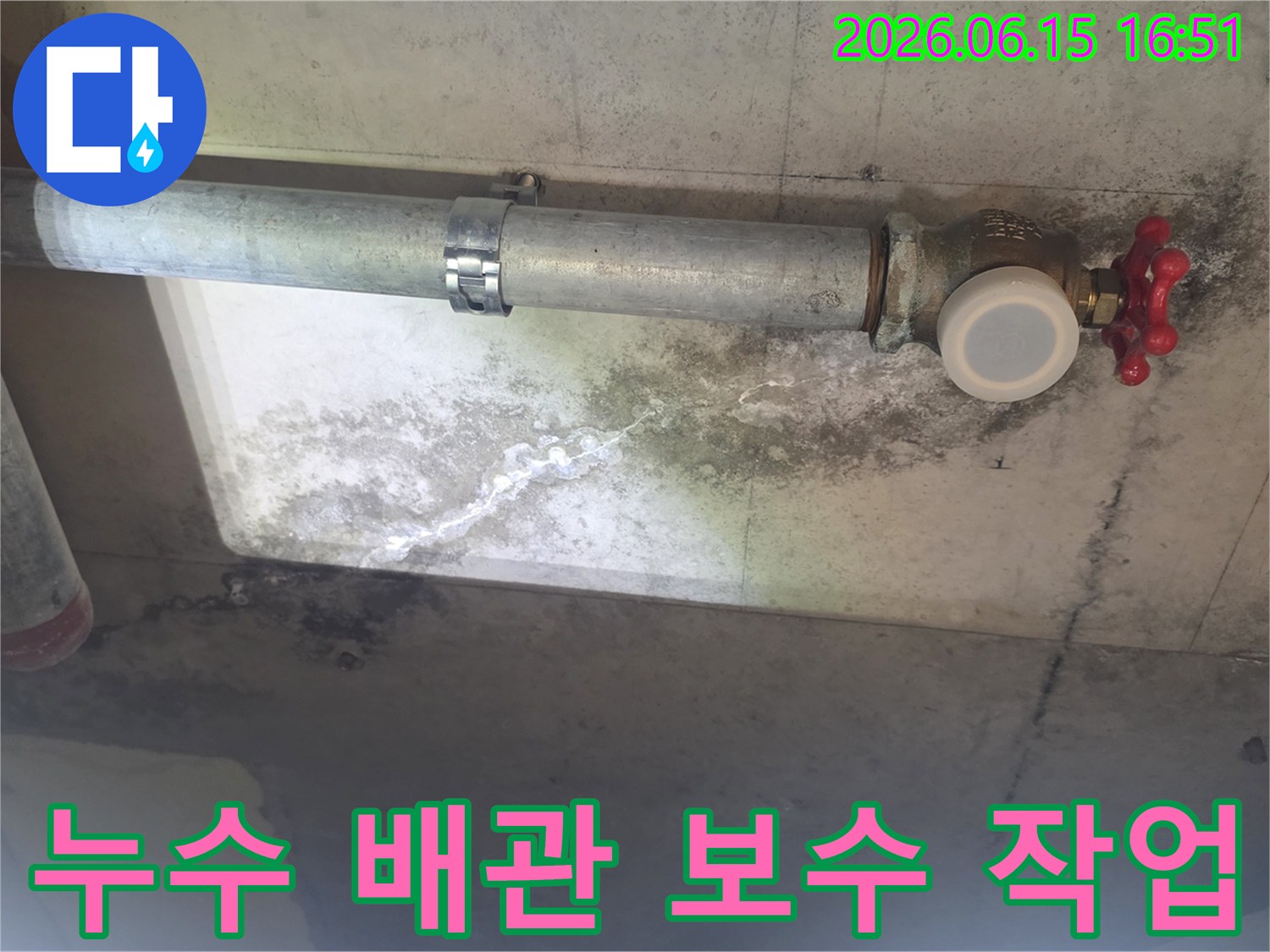 이 이미지는 노후된 배관에서 물이 새어-천장 콘크리트에 얼룩과-하얀 석회질 자국이 생긴 상황을 보여줍니다