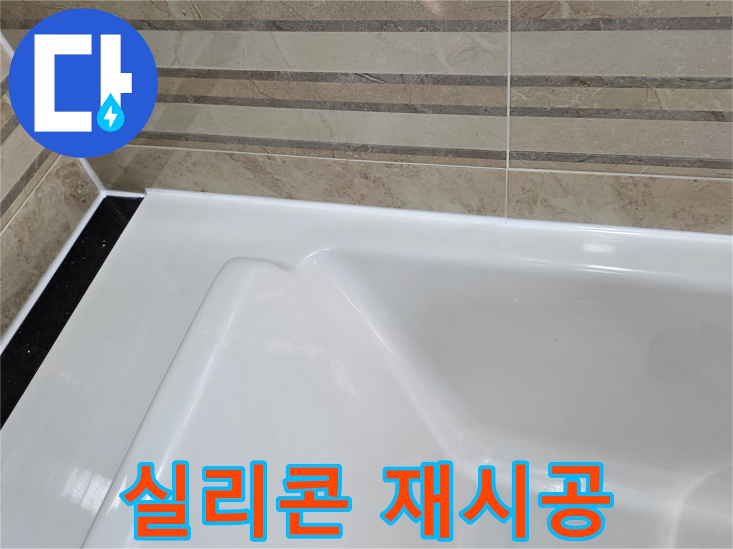 이 이미지는 욕실의 욕조와-벽 타일 경계면에-새롭게 시공된-깔끔한 방수 실리콘을 보여주며-이는 누수 예방을 위한-중요한 유지보수 작업의-결과입니다.