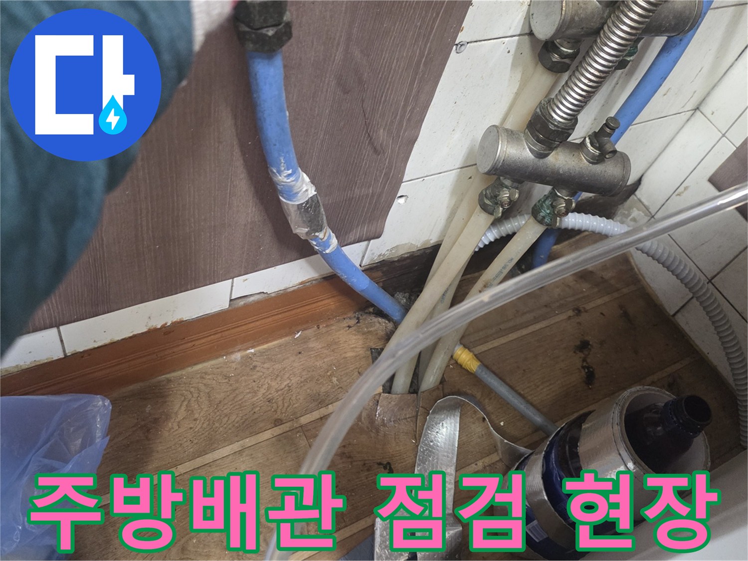 성남 수정구 주방 하부장 아래 복잡한 수도 배관과 점검 장비 모습
