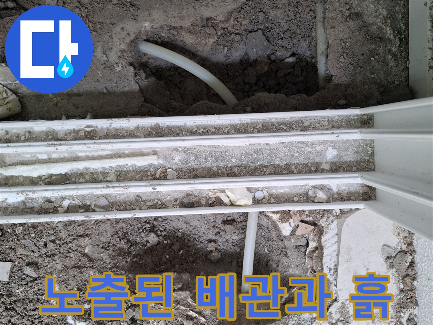 공사 중 드러난 - 하얀색 배관과 주변 흙더미