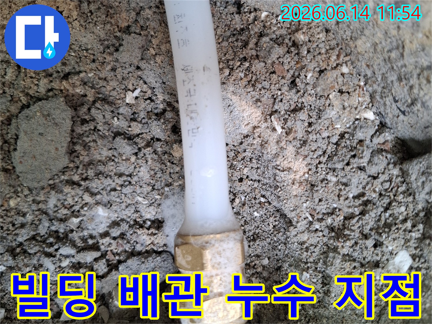 땅속에-매설된-빌딩-배관의-연결부에서-물이-새어나와-주변-흙이-젖어있는-누수-현장을-보여주는-사진
