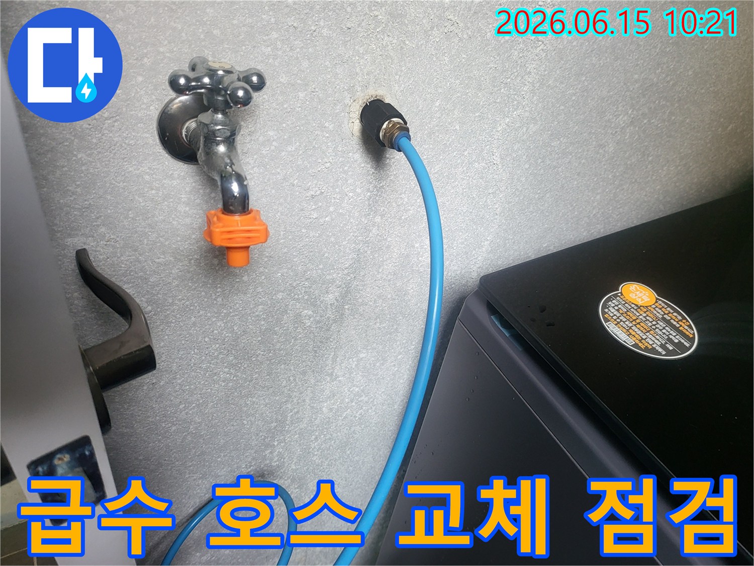 세탁실 벽면의 급수 호스 연결 부위를-전문가가 누수 여부를 확인하고-교체 작업을 준비하는 모습입니다.