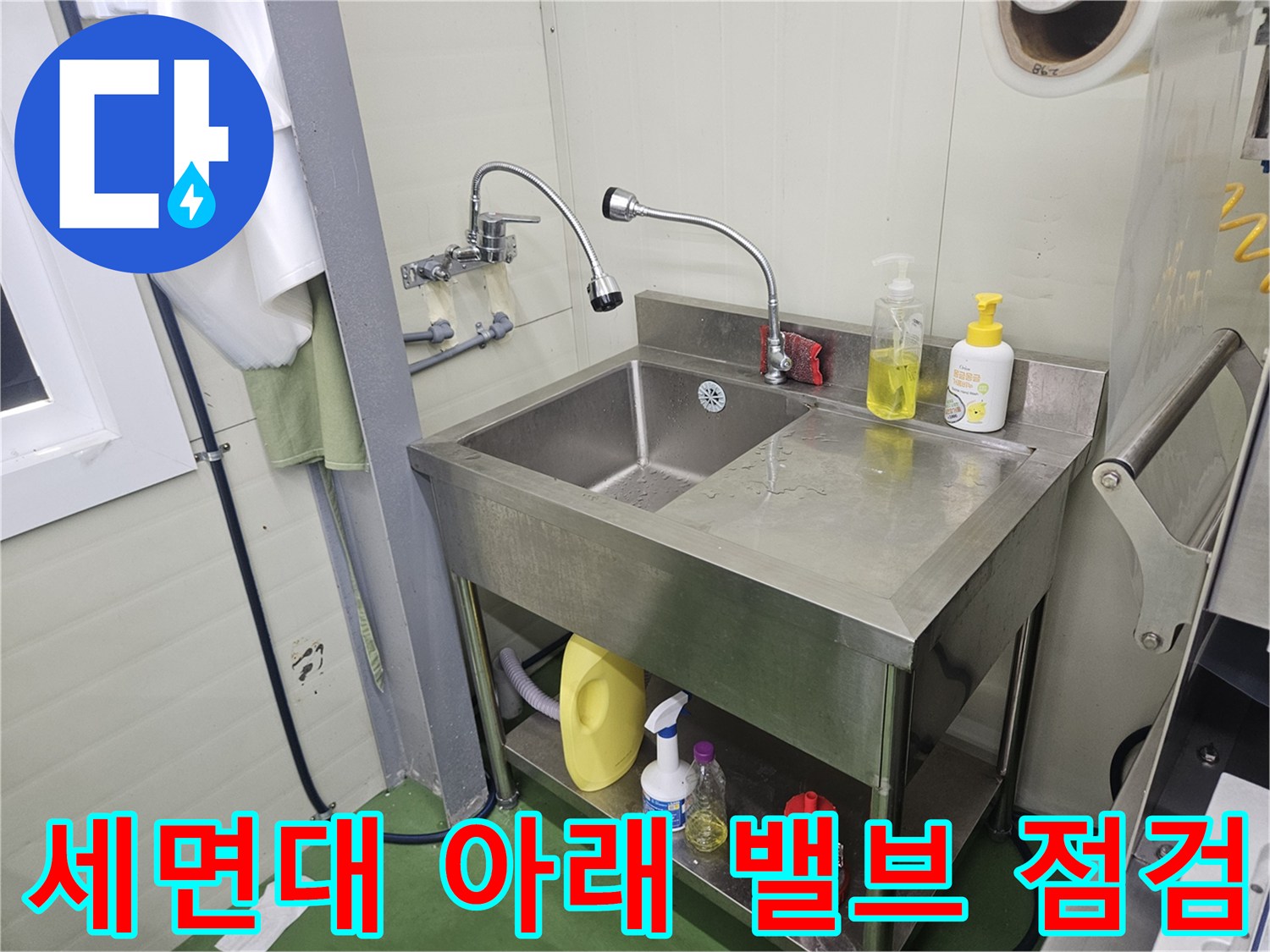 스테인리스 선반 아래 위치한 세면대 급수용 밸브와 호스