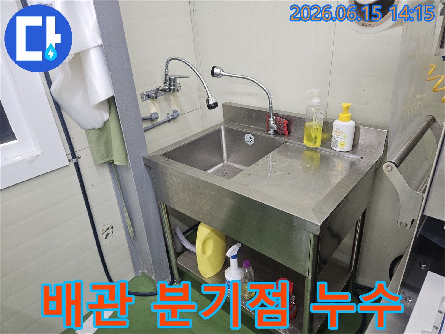 스테인리스-싱크대-뒤편-온수-냉수-배관-분기점에서-물이-새는-것을-점검하는-누수-전문가의-모습