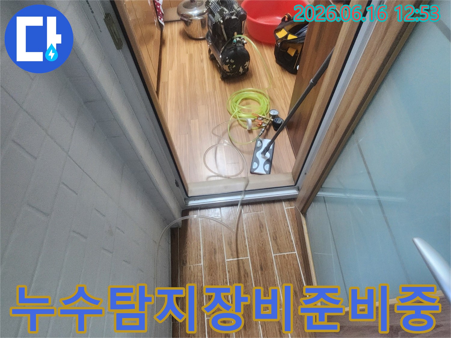 누수 엔지니어가 아파트 내부에서 누수-탐지 장비를 꼼꼼하게 준비하며 작업을 시작하는 모습입니다.