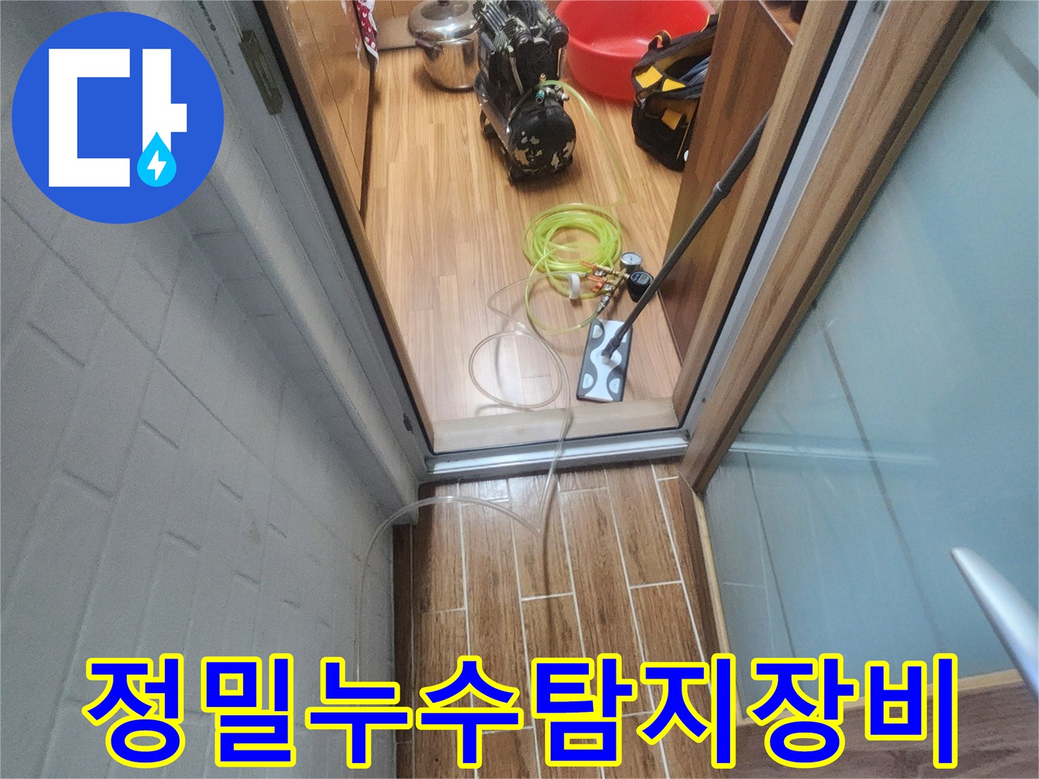 누수 엔지니어가 아파트 실내에서 정밀 누수-탐지 장비를 연결하며 작업 준비를 하고 있습니다.