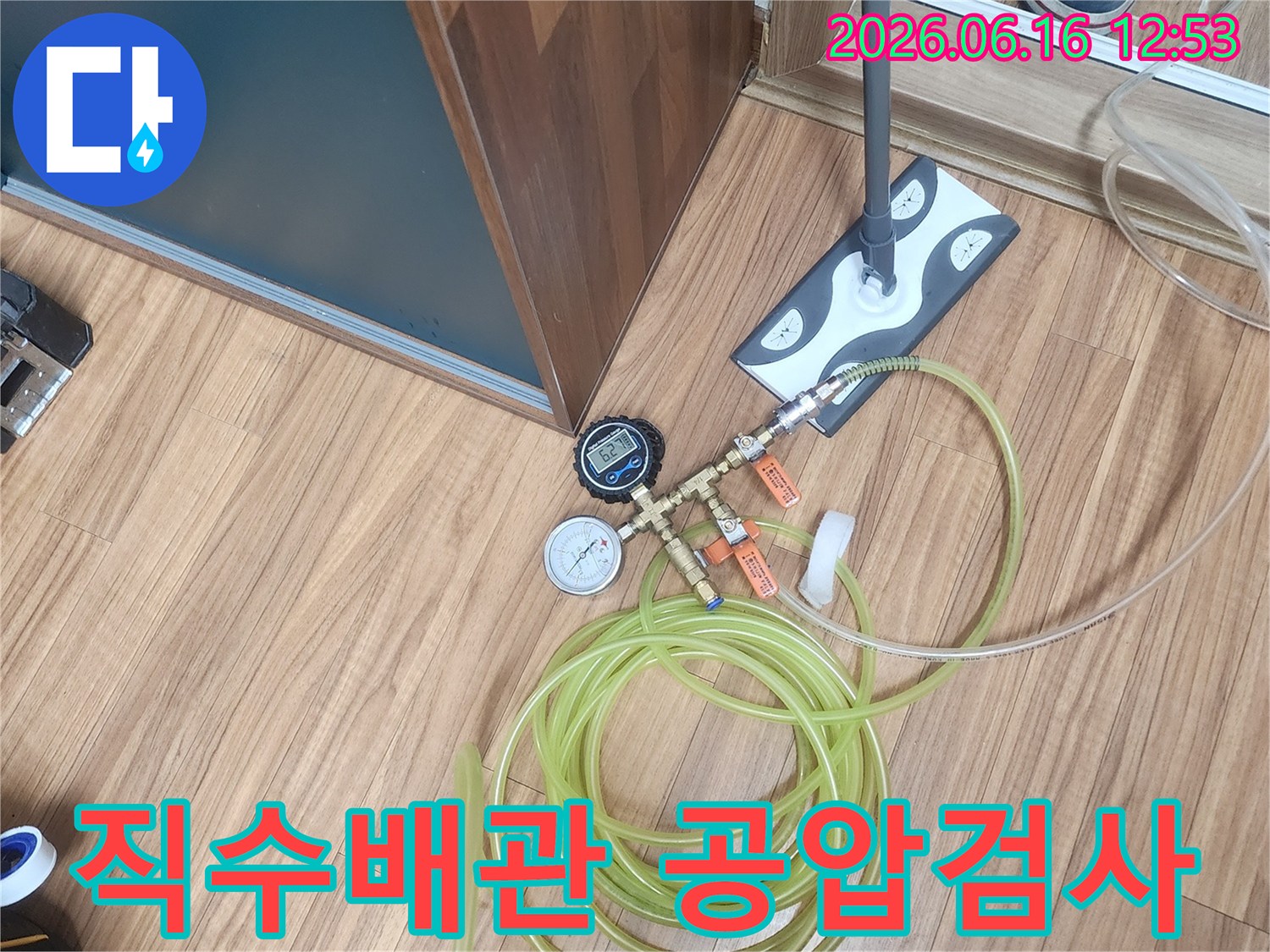 누수 엔지니어가 아파트 직수 배관의 누수 여부를 확인하기 위해 공압 검사 장비를 설치하는 모습