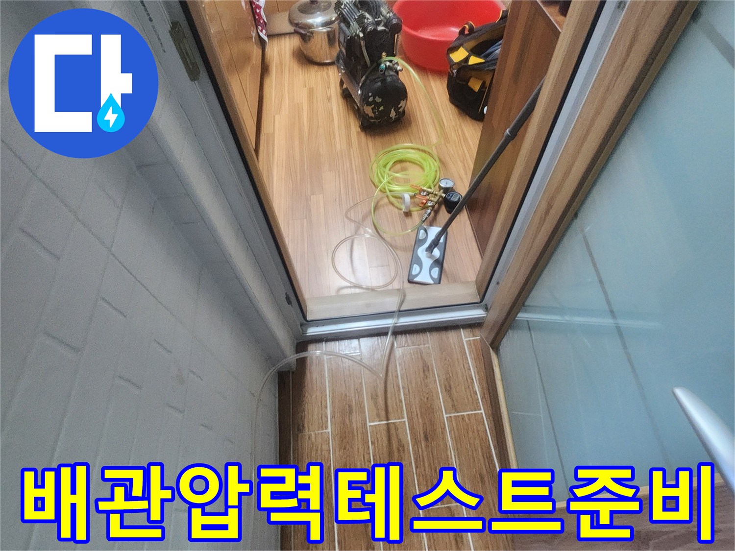 아파트 내부에서 누수 엔지니어가 배관 압력-테스트를 위한 장비 연결을 진행하고 있습니다.