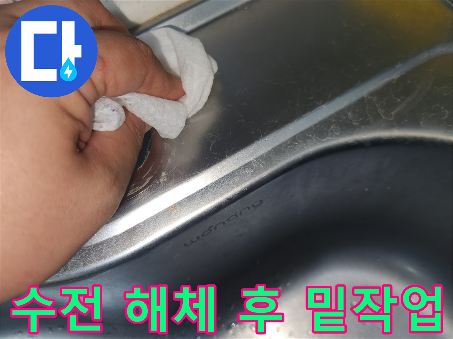 싱크대 상판의 수전 구멍 주변을- 젖은 천으로 꼼꼼히 닦아내는 손의 모습입니다