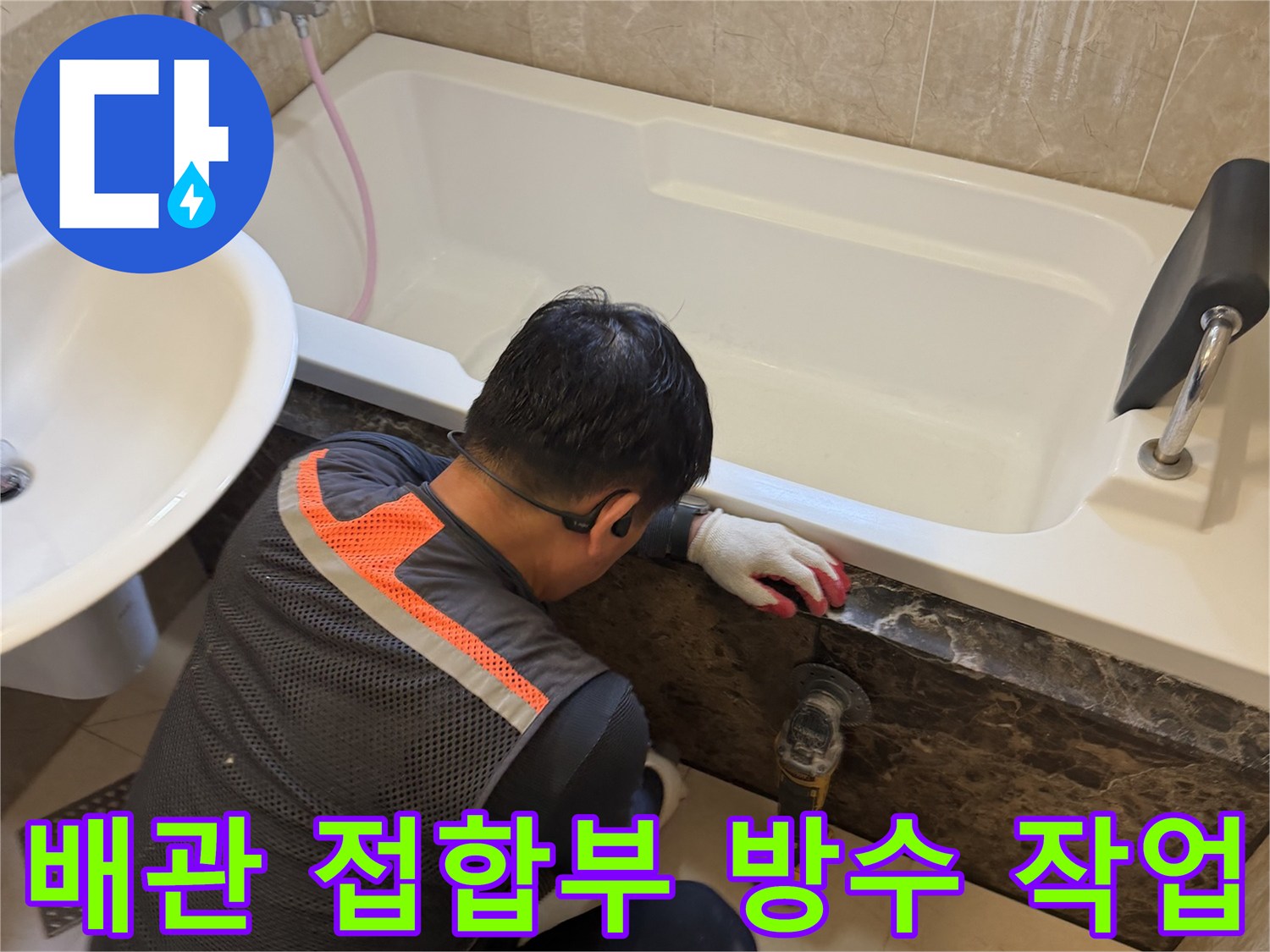 욕조 하단 배수구 주변의 틈새를 메우기 위해 전문 장비를 사용하는 모습