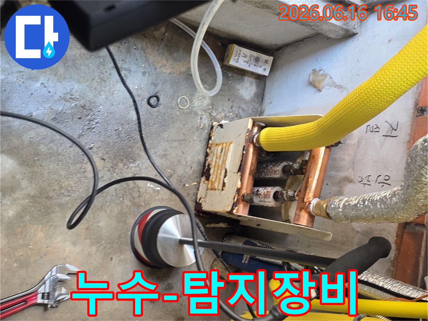 누수-전문-엔지니어가-청음식-탐지기로-누수-지점을-찾아내어-문제-해결의-첫걸음을-시작하는-모습