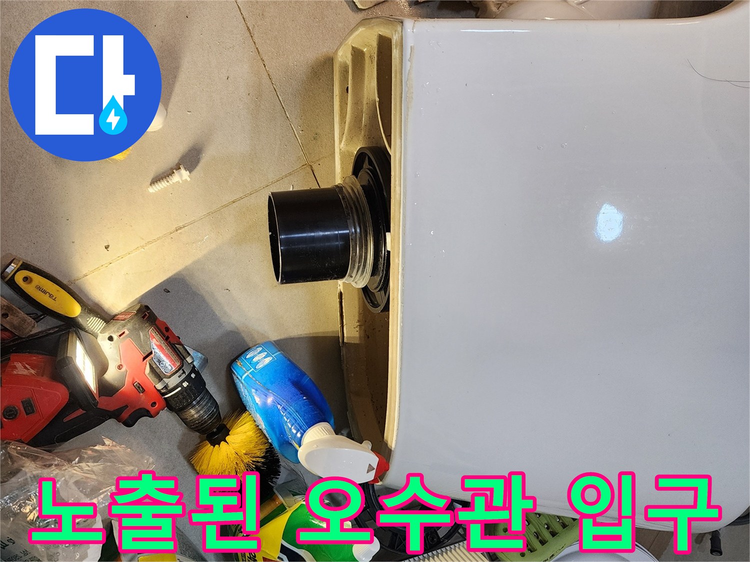 변기를 탈거하여 드러난 배관 입구와 주변 작업 도구들입니다.