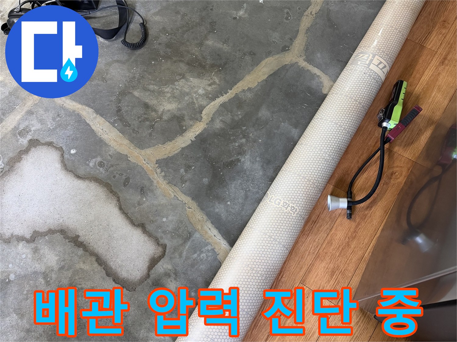 배관 누수 여부를 판단하기 위해 설치된 공압 테스트 장비와 젖은 바닥면