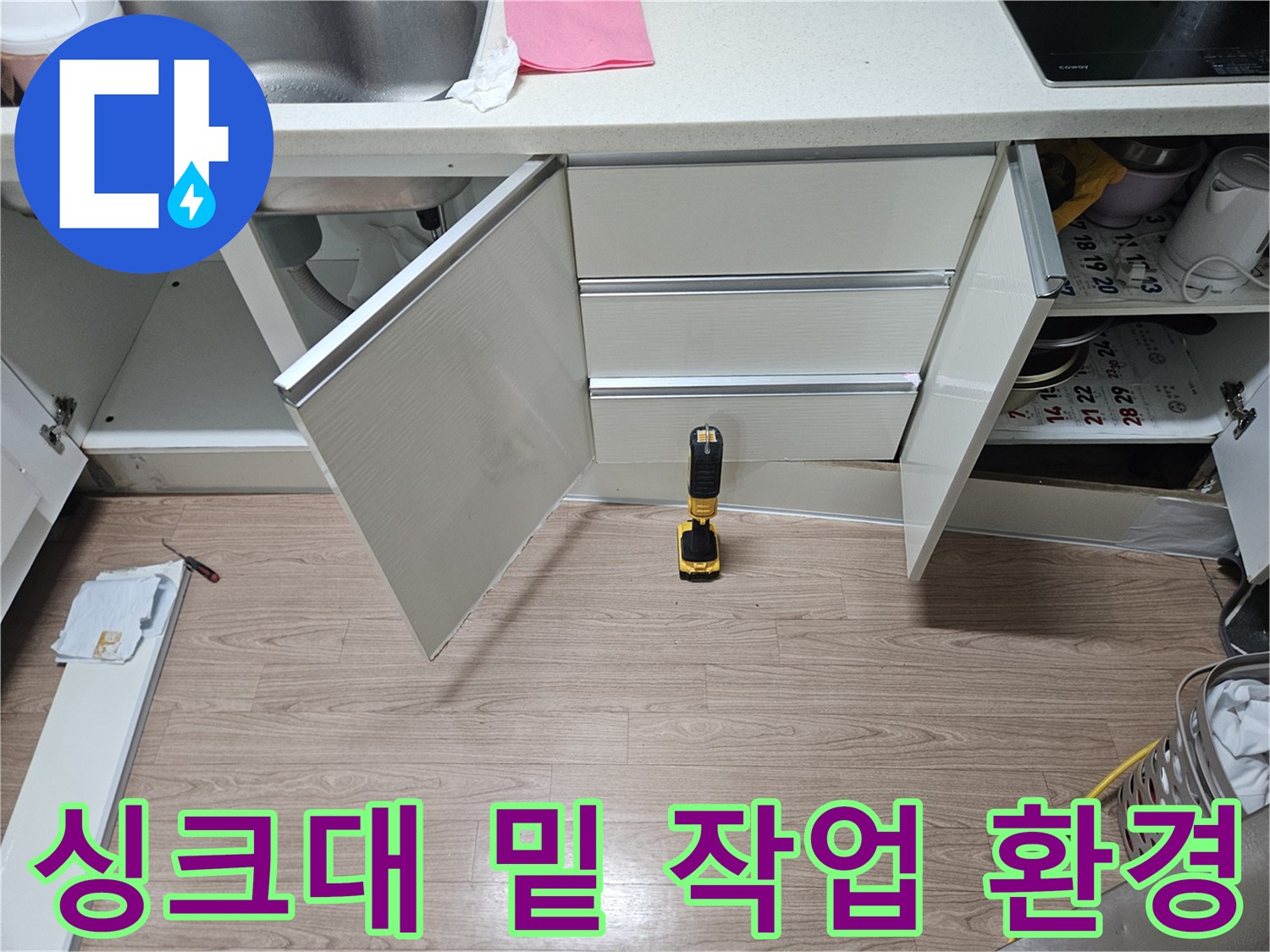 싱크대 하단 수납 공간의 내부 모습 - 배관 점검을 위한 준비 과정