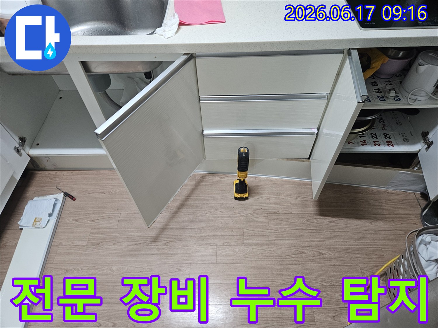 싱크대-하부-누수-탐지를-위해-전문-장비인-전동-드릴을-활용하여-점검하는-현장