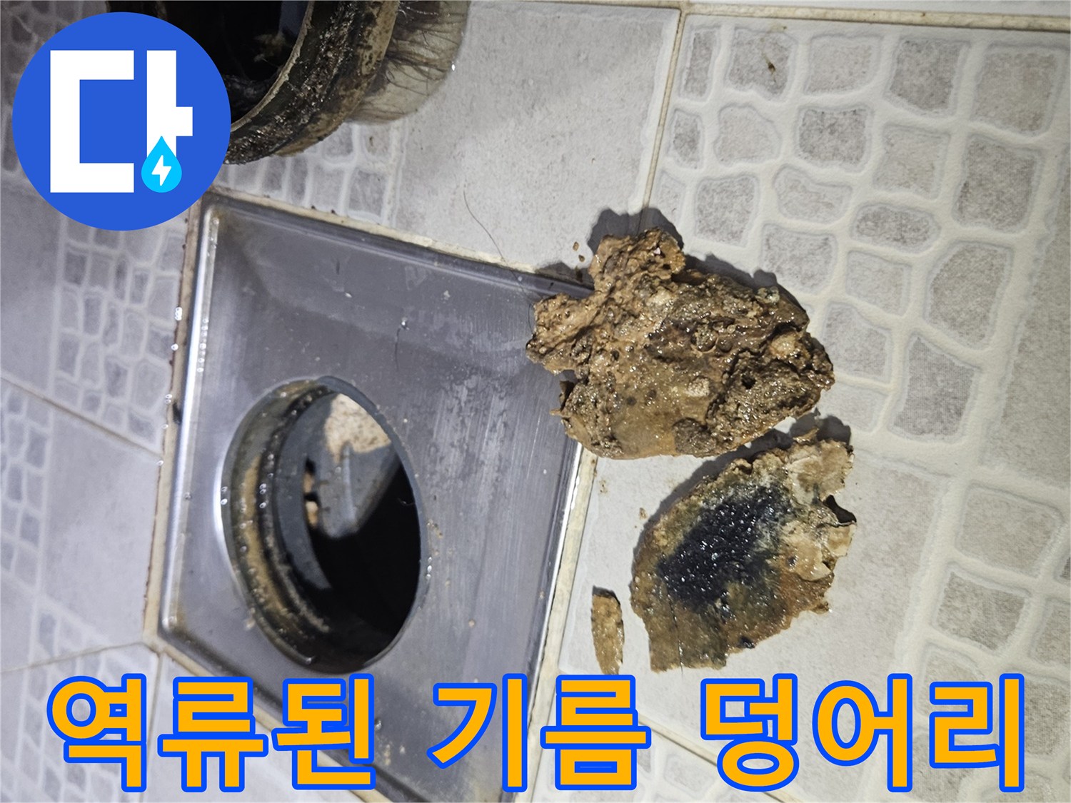 배수구 통로를 막고 있는 커다란 갈색 기름 슬러지와 오염물질