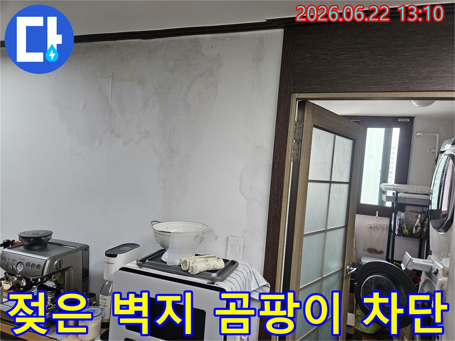 천장 누수로 인해-주방 벽면의 벽지가 젖고-얼룩이 생긴-아파트 내부의 손상된 벽 모습