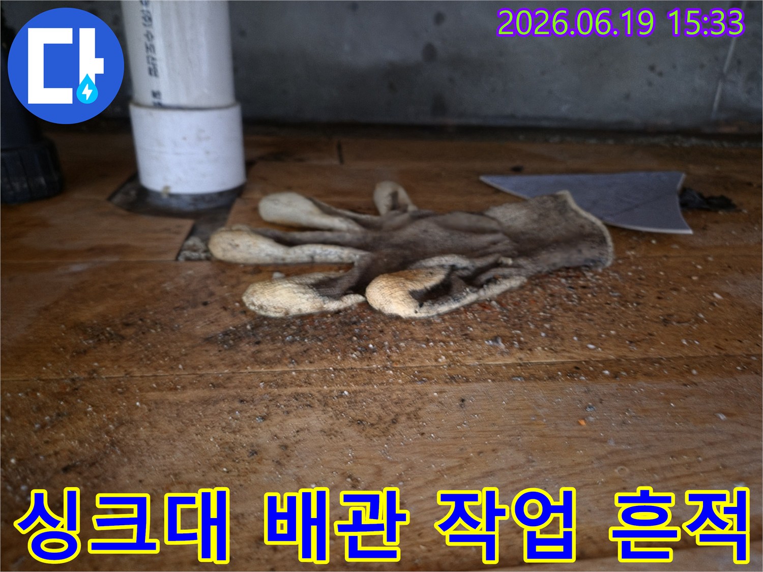 이 이미지는-싱크대 역류로-인한-배관 공사 현장의-작업용 장갑과-주변의-오염된-모습을-보여줍니다