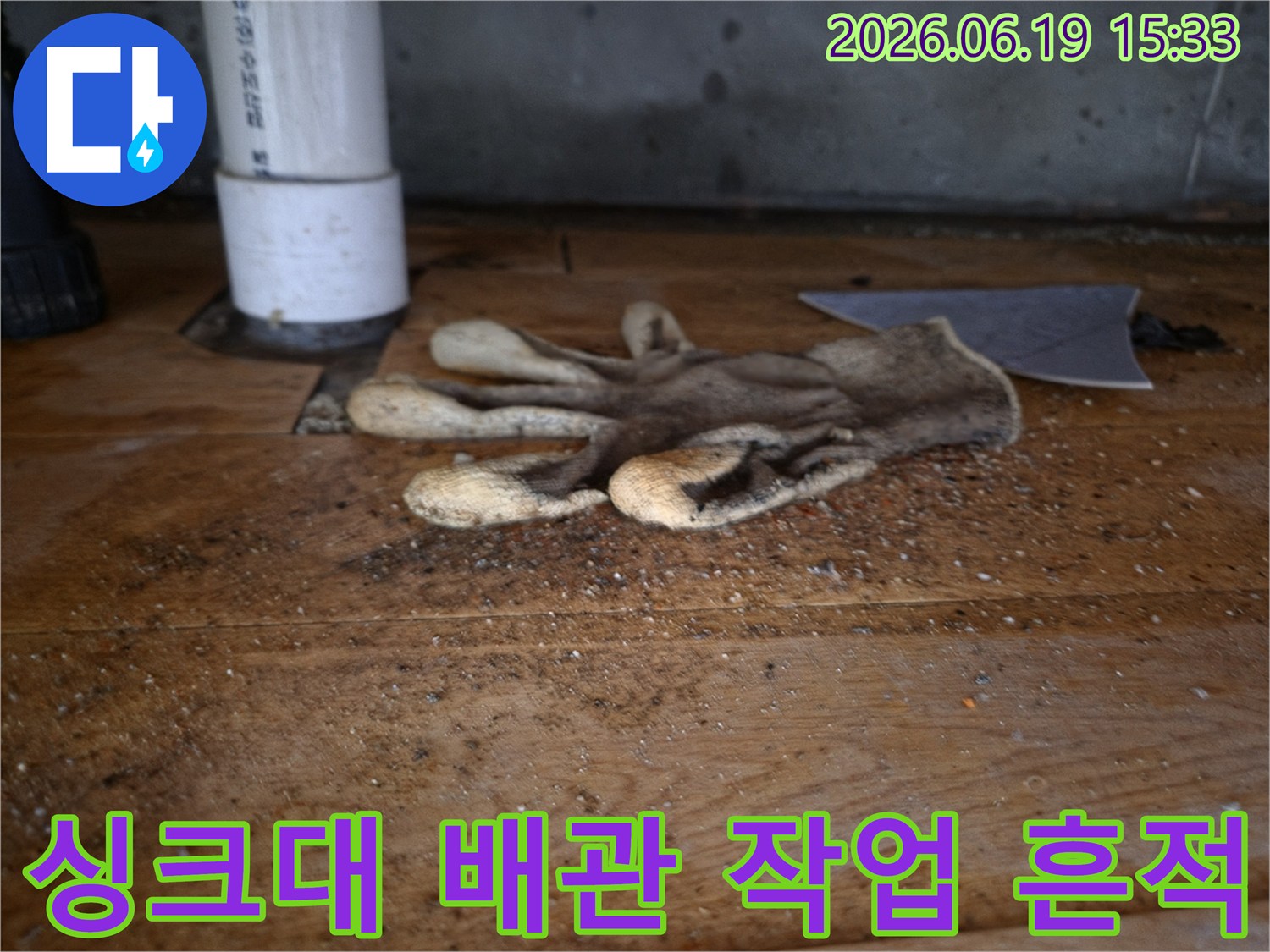 이 이미지는-싱크대 역류로-인한-배관 공사 현장의-작업용 장갑과-주변의-오염된-모습을-보여줍니다