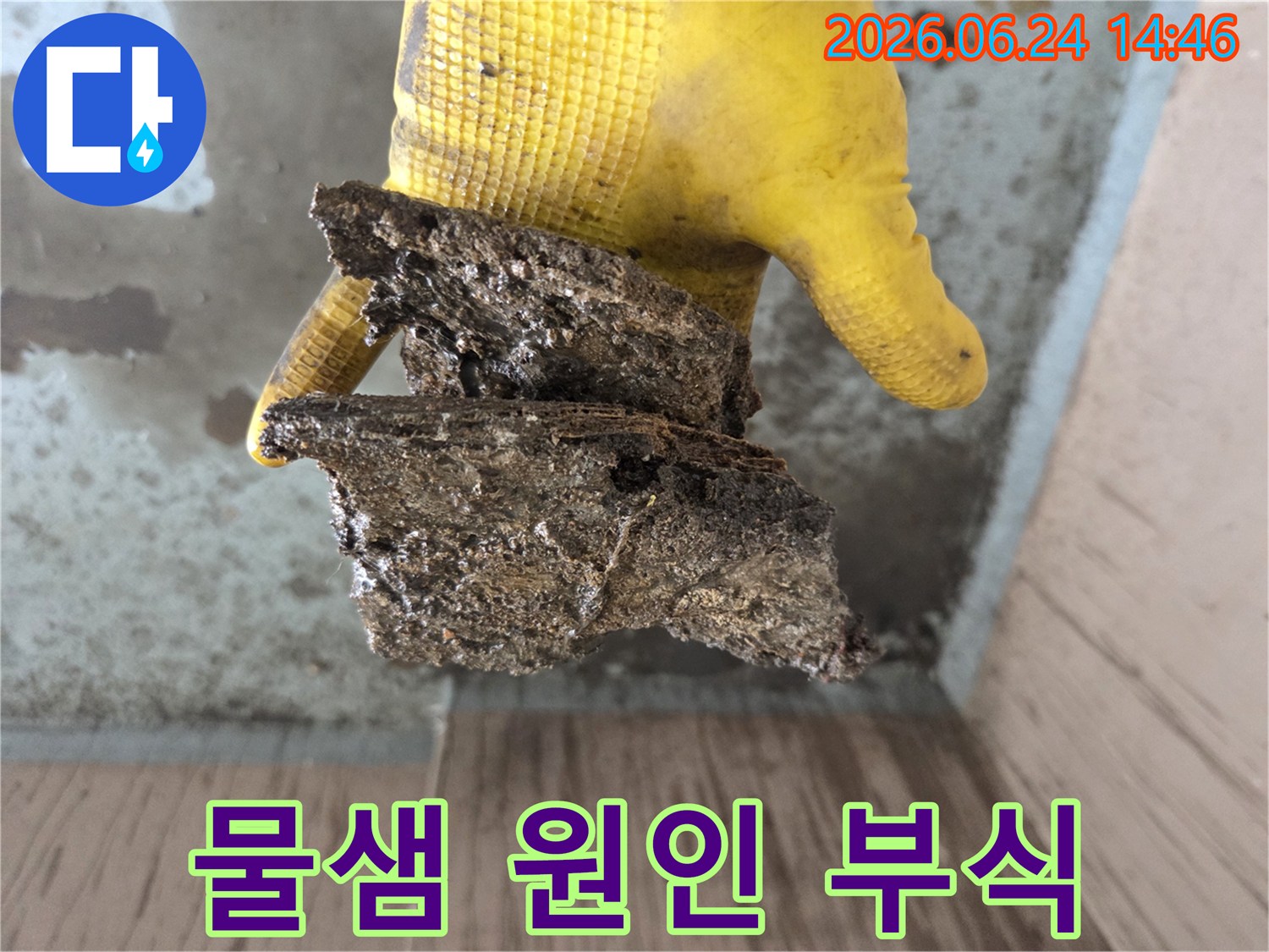 성북구-누수-현장에서-배관-내부의-심각한-부식으로-인해-떨어져-나온-이물질을-작업자가-보여주는-모습입니다.