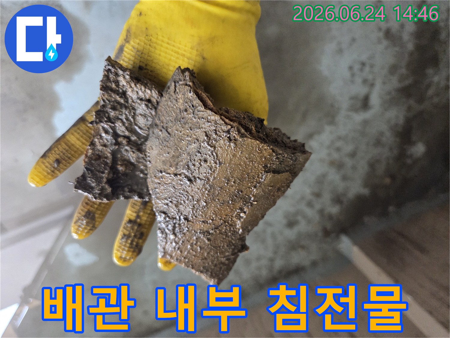 수도관-내부의-심각한-부식-상태를-시각적으로-확인시켜-주는-갈색-파편들을-든-손