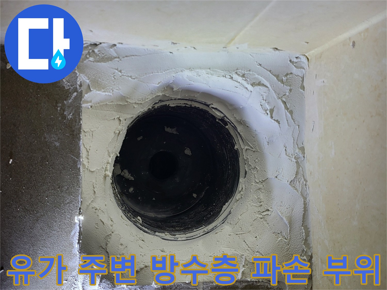 하수구 배관 주위의 노출된 시멘트와 균열 상태입니다.