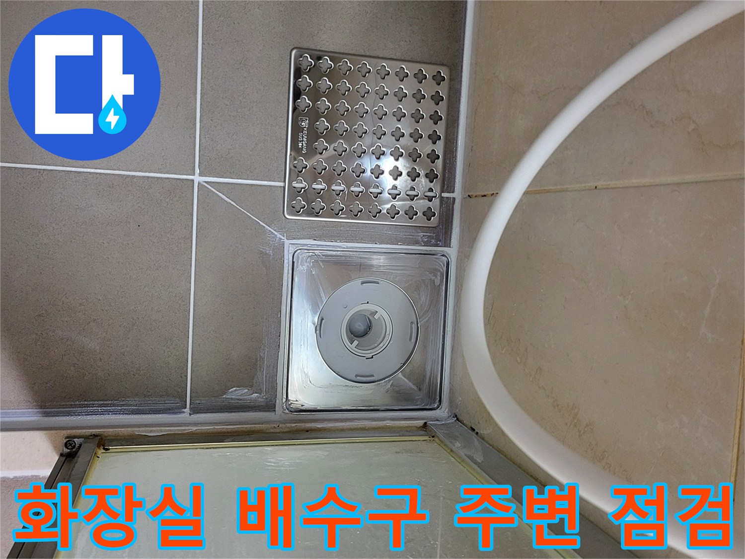 하수구 유가 덮개와 주변 타일의 접합부 근접 촬영