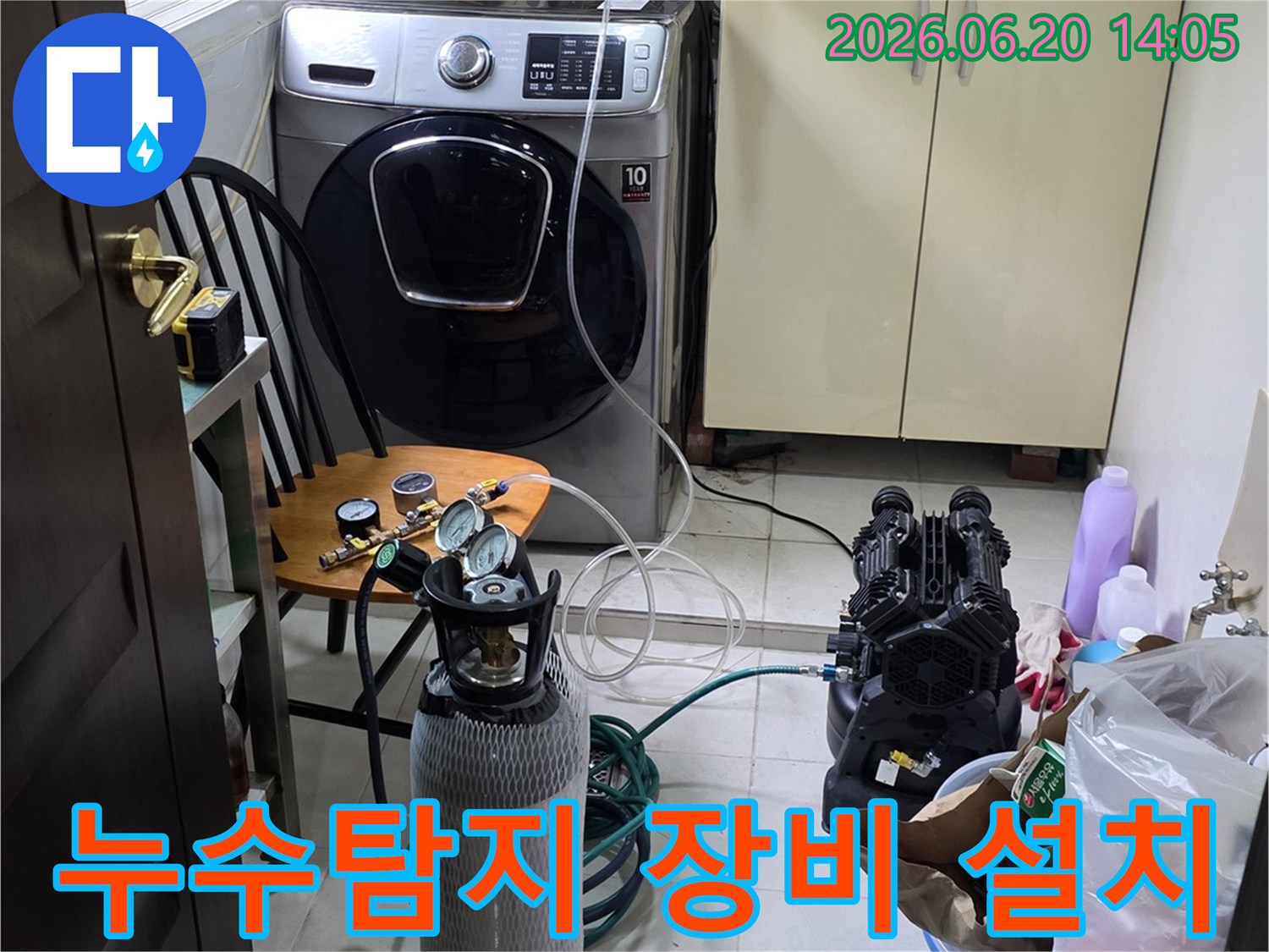 세탁실 배관 누수 확인을 위해-전문 탐지 장비를 설치하고-압력 검사를 진행하는 모습