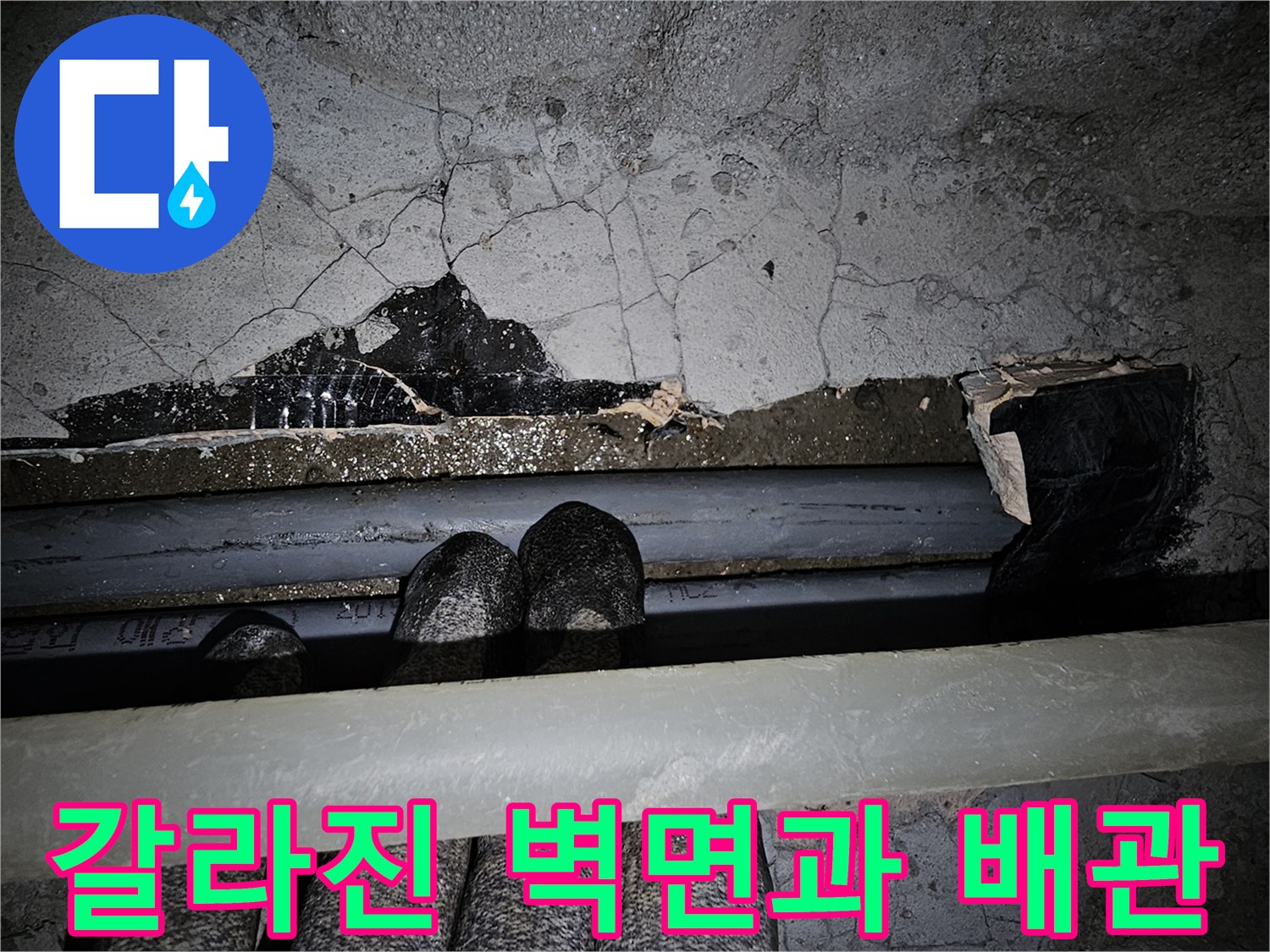 균열이 발생한 콘크리트 벽면-노출된 배관 부위
