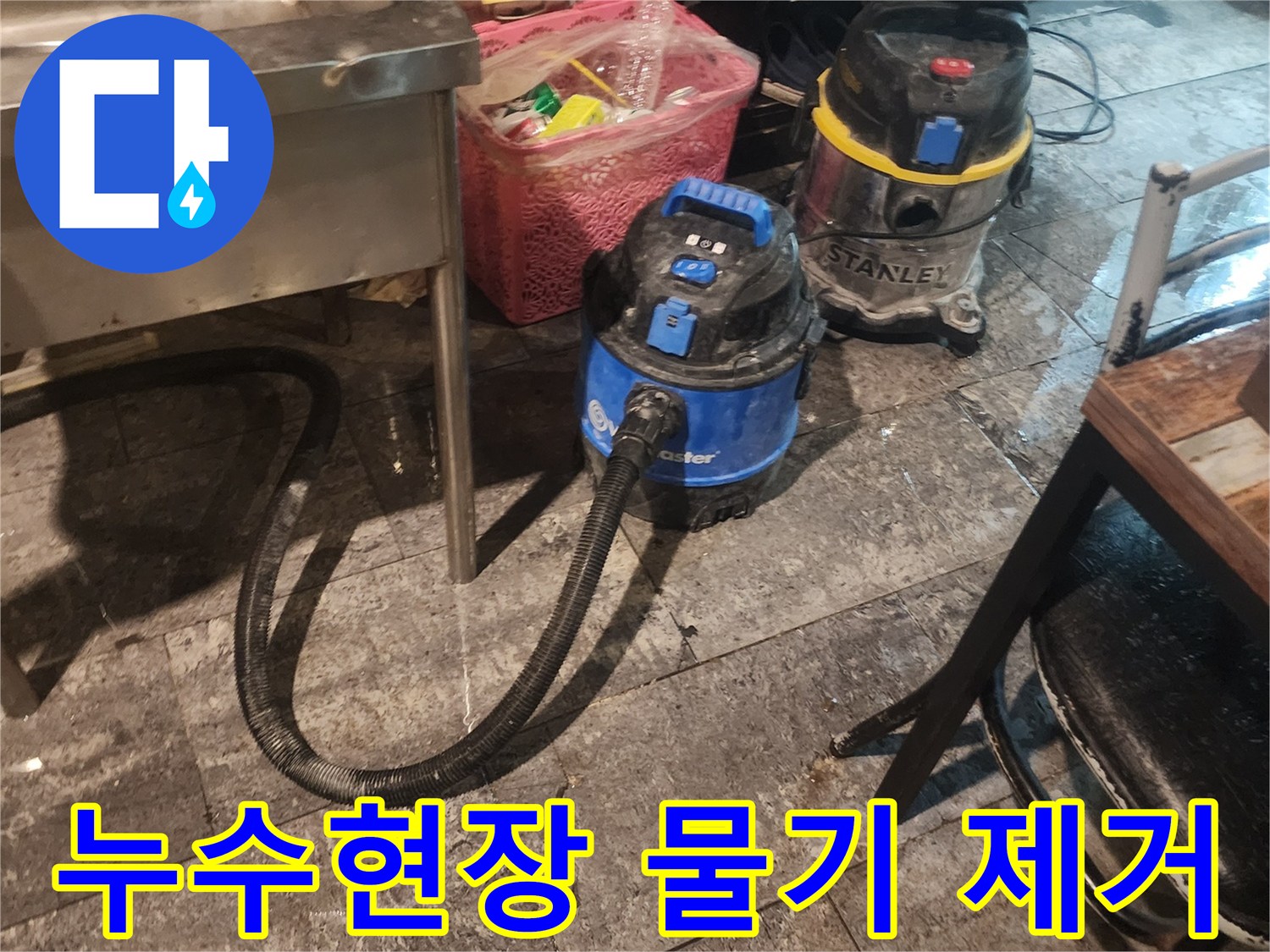 누수 현장에서-바닥의 물기를-흡입하고-습기를 제거하기 위해-사용되는-산업용 석션 장비 두 대가-놓여있는 모습입니다.