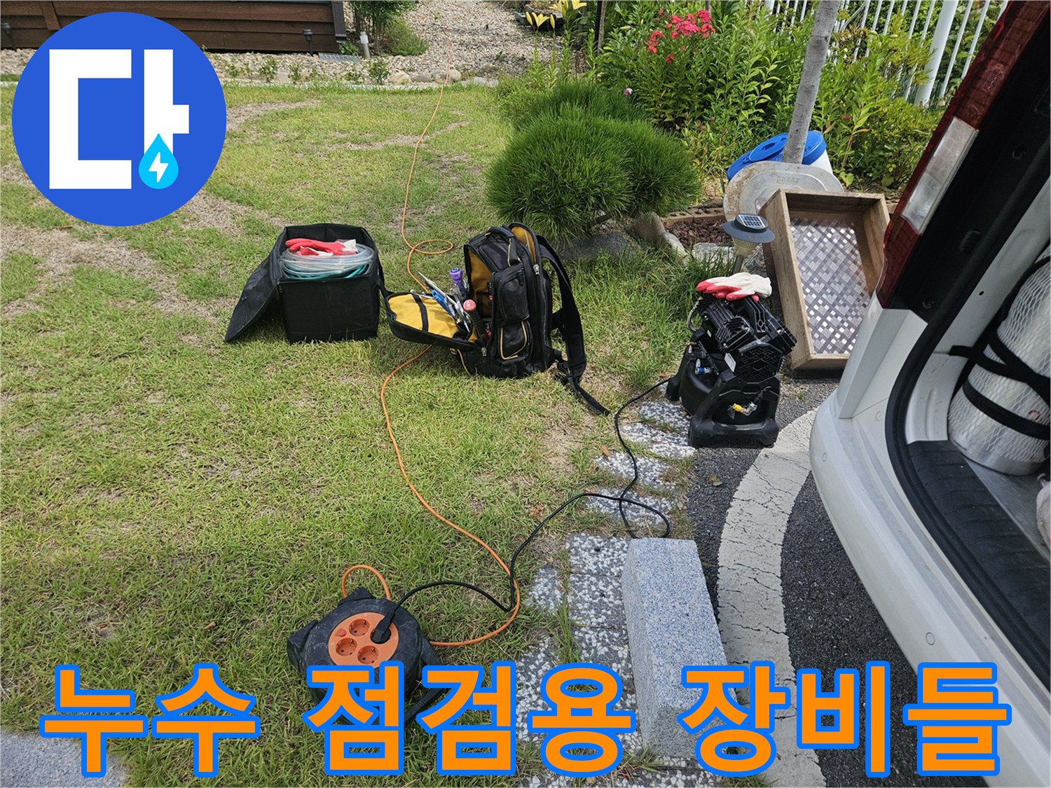 잔디밭 위에 놓인 가스 탐지기와 청음기 및 작업용 도구들