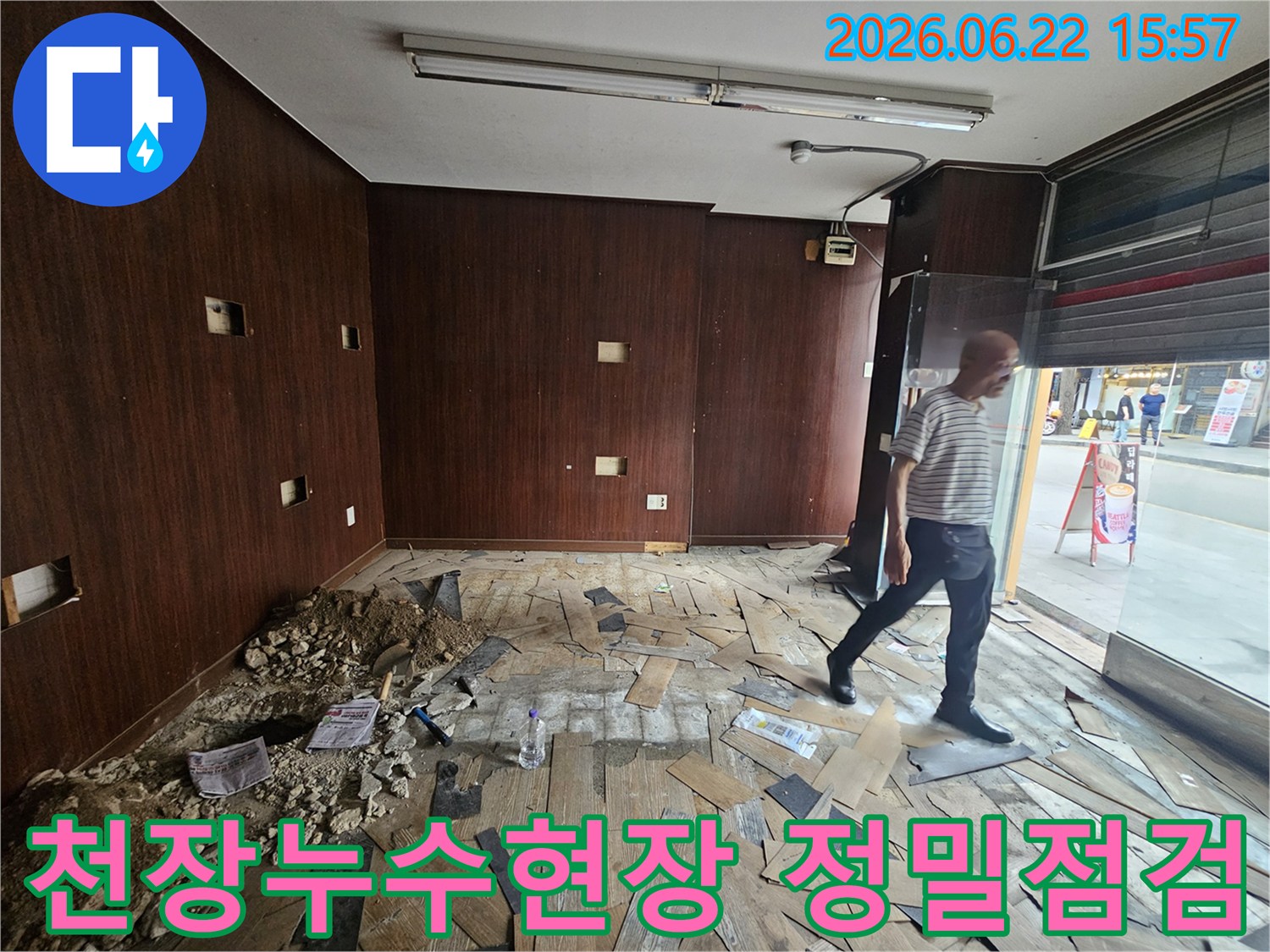 이 이미지는-천장 누수로 인해-내부 마감재가 손상된-상가 건물 내부를-보여주고 있습니다-누수 엔지니어가-현장을 면밀히-살피는 모습입니다.