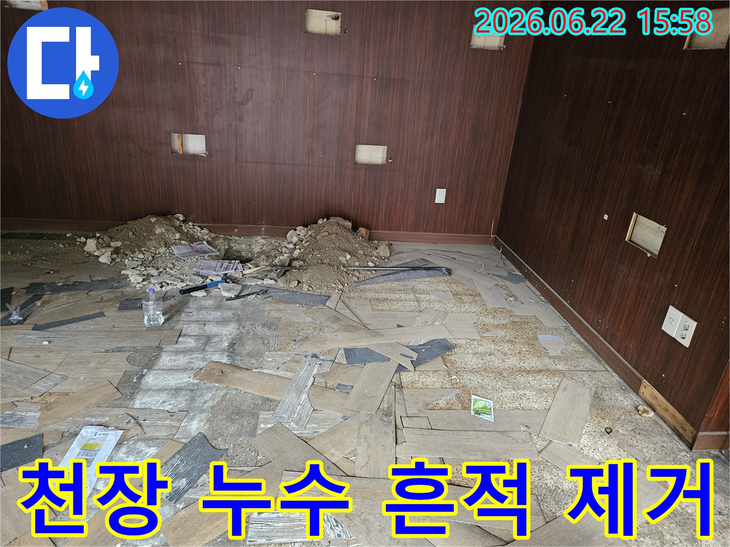이 이미지는 천장 누수로 인해 마감재가 붕괴된 현장에서-누수 흔적을 제거하고 재도장 작업을 준비하는 모습을 보여줍니다
