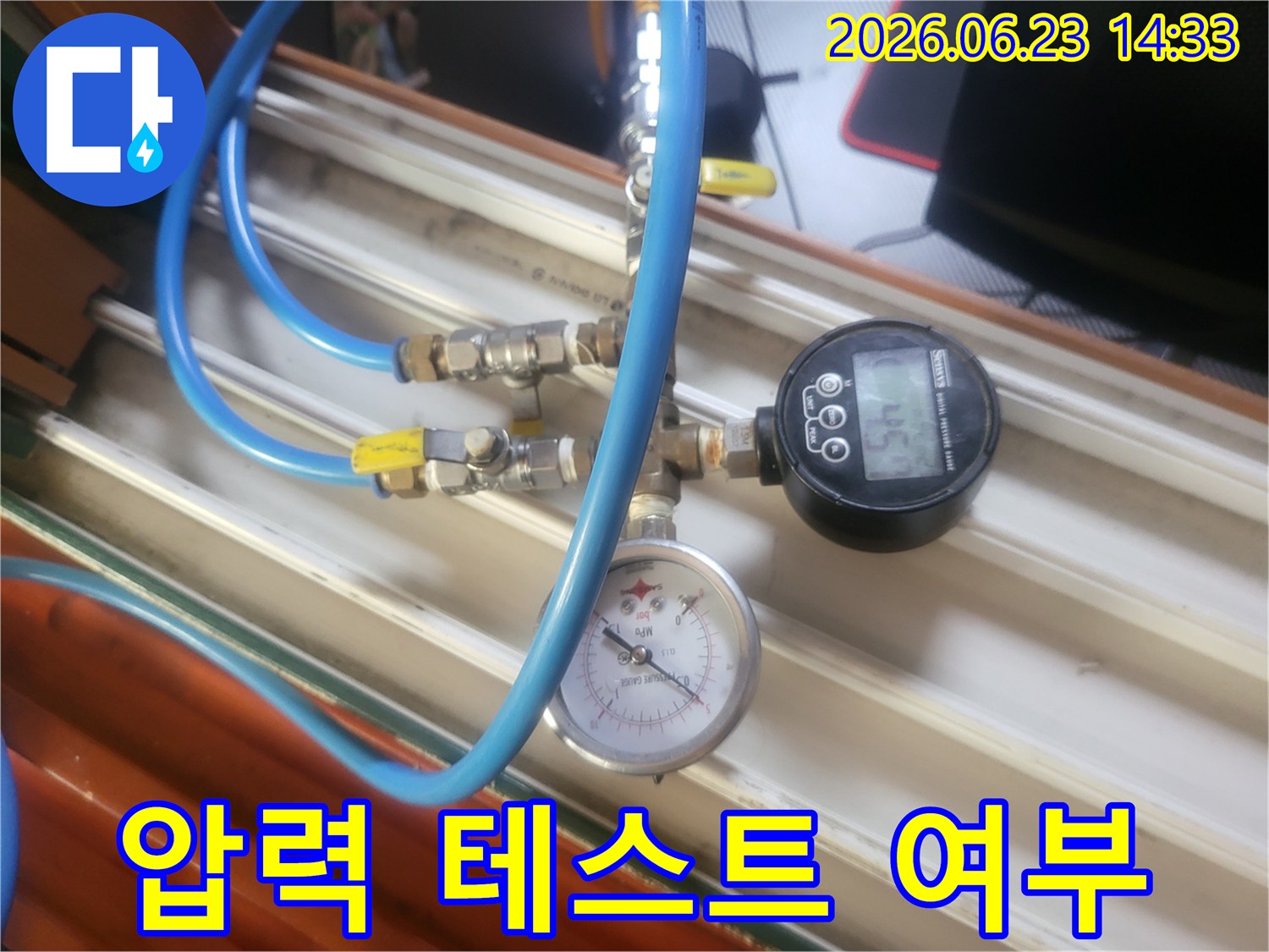 파란색 호스와-다양한 밸브-그리고 압력계가 연결된-누수 탐지 장비가-작동 중인 모습입니다.
