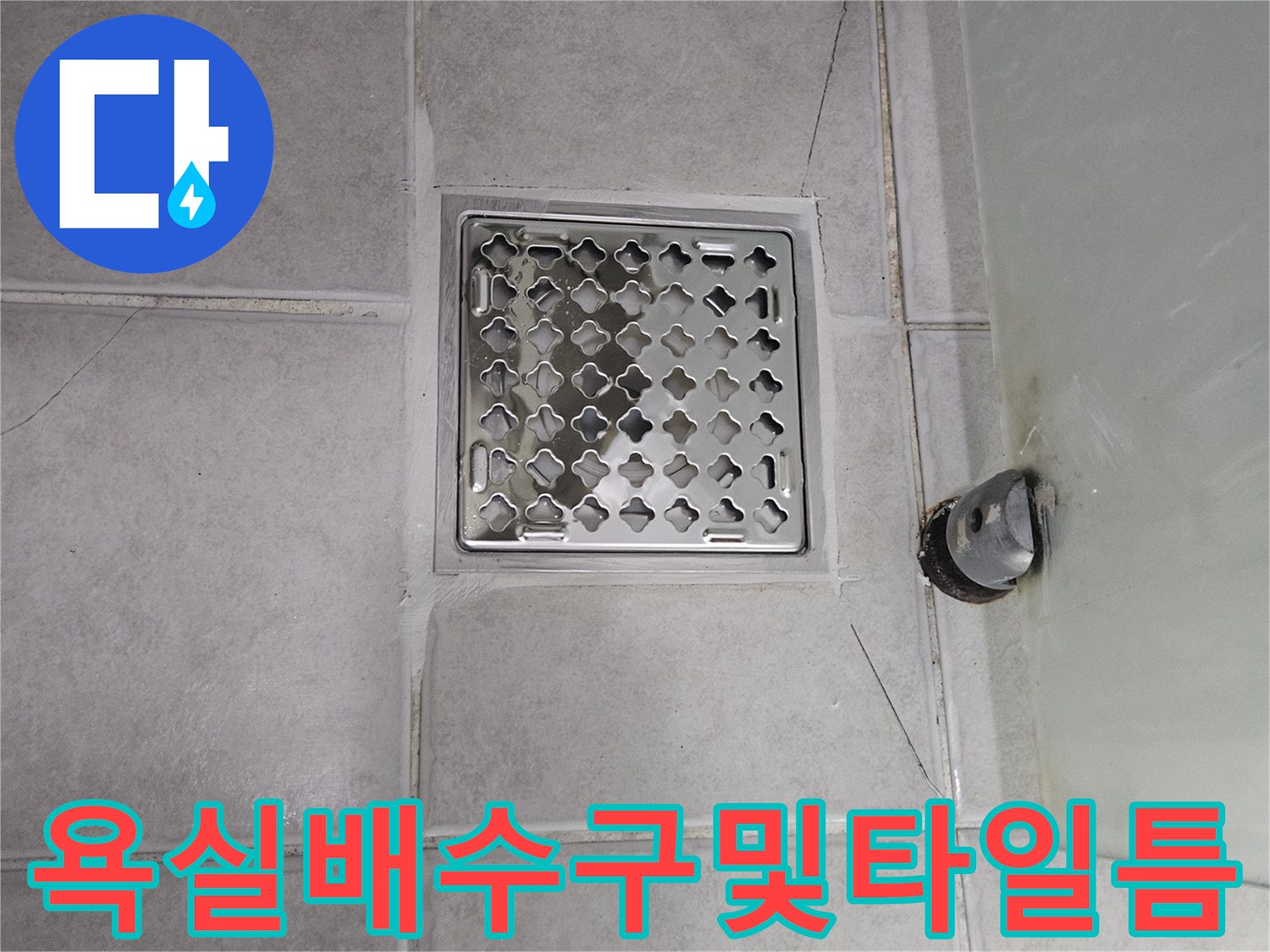 금이 간 타일과 노출된 하수관의 연결 상태를 보여줍니다.