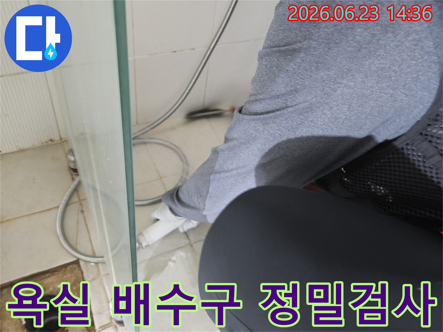 누수 전문가가-욕실 바닥의 배수구 주변을-집중적으로 검사하여-누수 원인을 파악하고 있습니다.