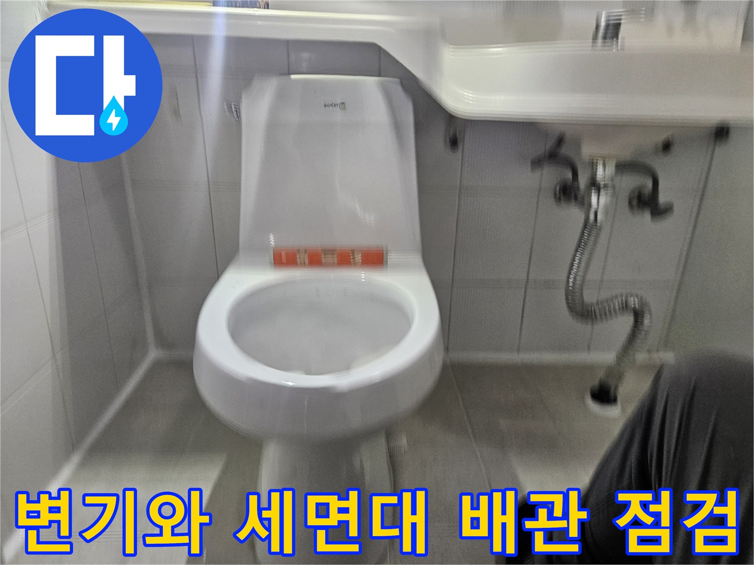 화장실 변기 하부와 세면대 아래 배수관의 연결 상태를 촬영한 사진