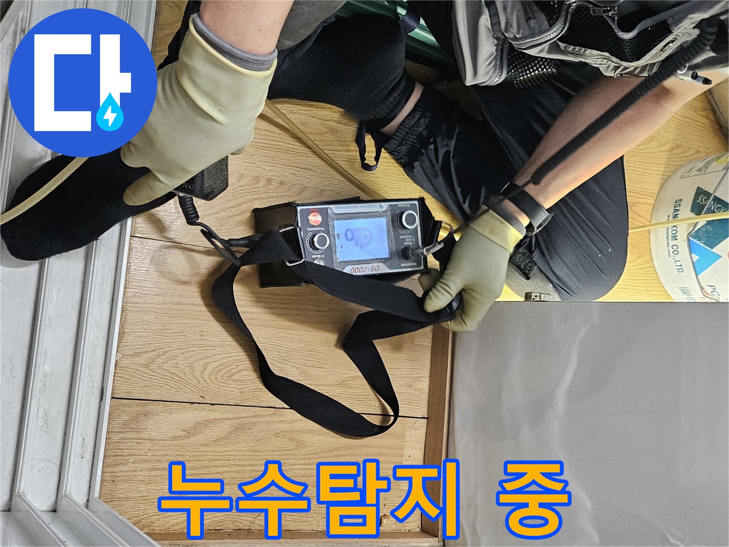 누수 전문 엔지니어가-탐지 장비로-바닥 누수 지점을 찾아내고 있습니다.