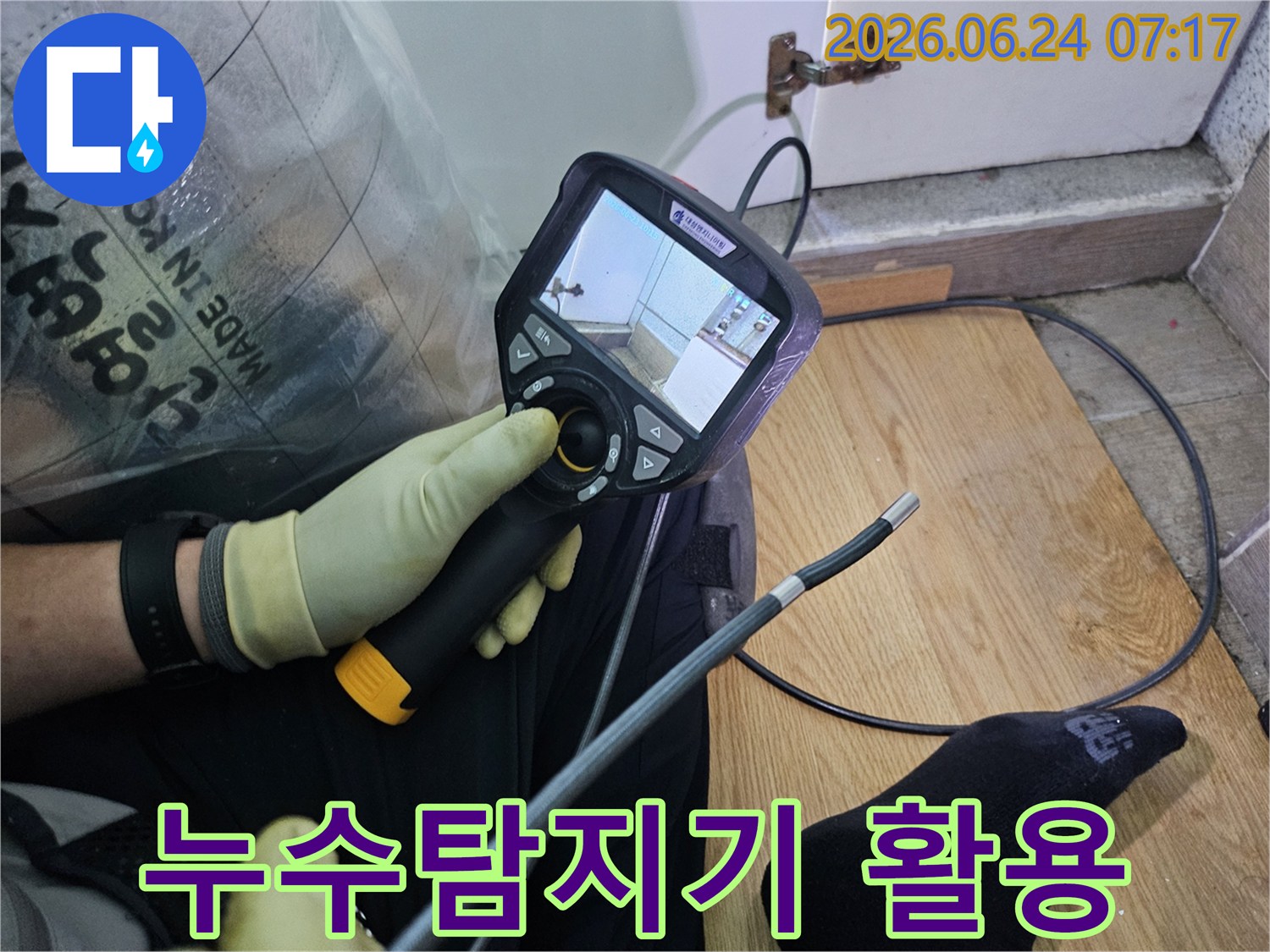 이 이미지는-숙련된 기술자가-누수 문제를 해결하고자-내시경 탐지기로-숨겨진 배관의 상태를 확인하는 과정입니다.