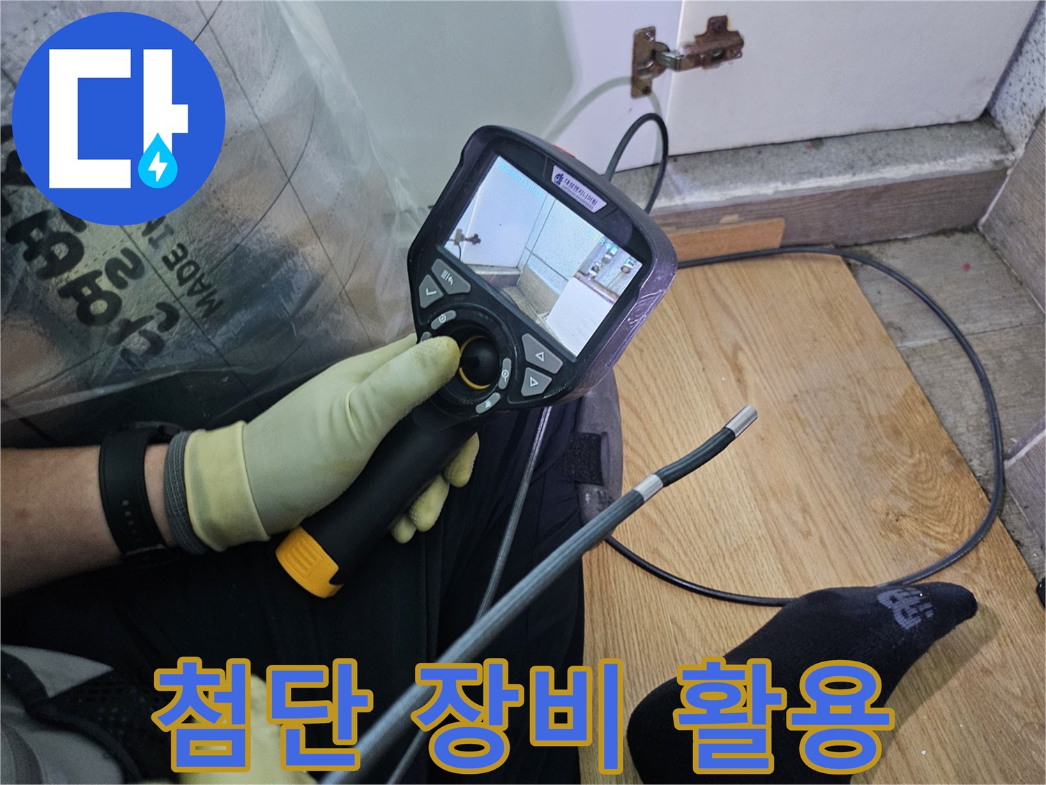 이 이미지는-숙련된 기술자가-누수 문제를 해결하고자-내시경 탐지기로-숨겨진 배관의 상태를 확인하는 과정입니다.
