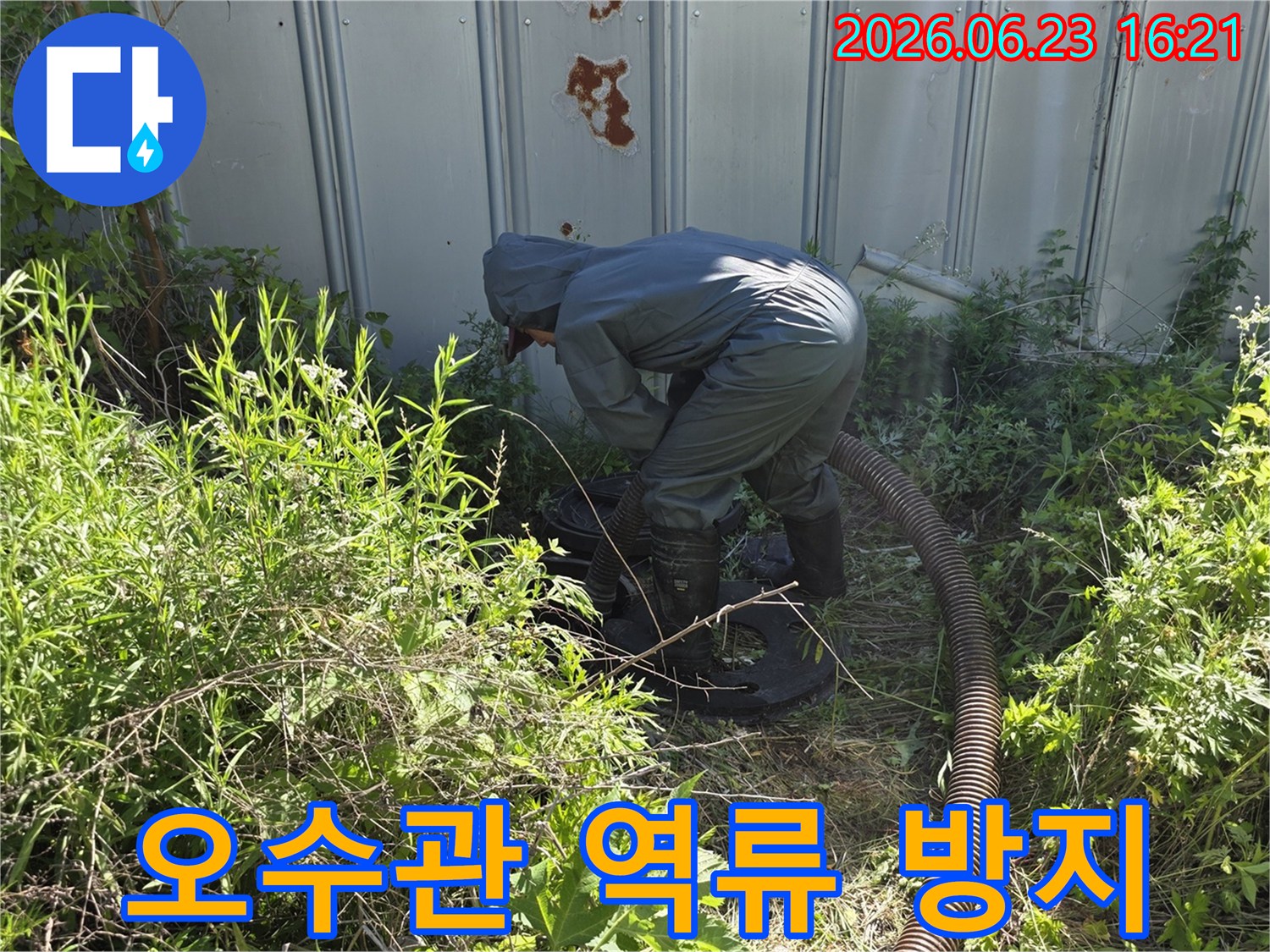 전문 작업자가 보호복을 입고 오수관 역류를 방지하기 위해 흡입 작업을 진행하는 모습