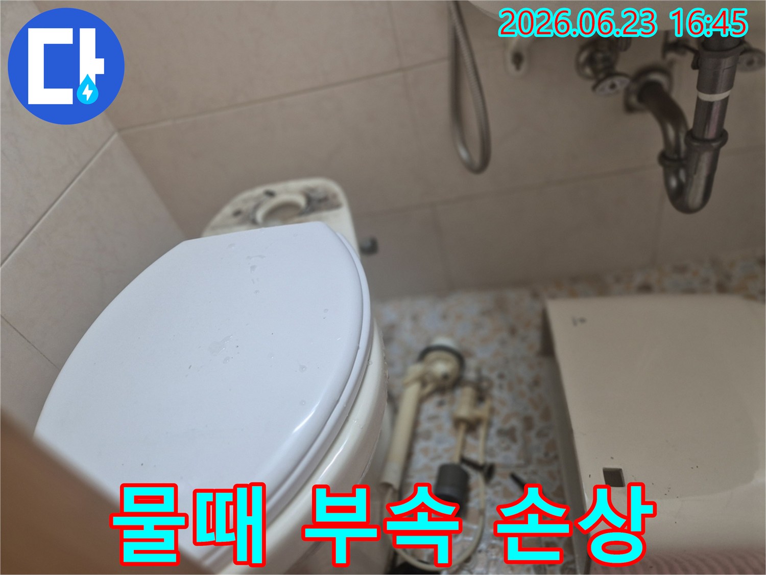 변기 물탱크에서-분리된 부속품들에-낀 물때와 석회질로 인한-손상 상태를-확인하는-수리 현장입니다.