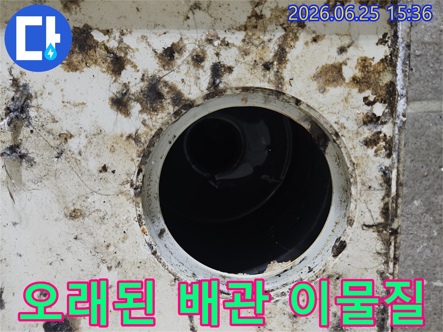 오래된 배수구 주변에 쌓인 거뭇거뭇한 이물질과 곰팡이-배관 노후화와 누수의 징후를 보여줍니다