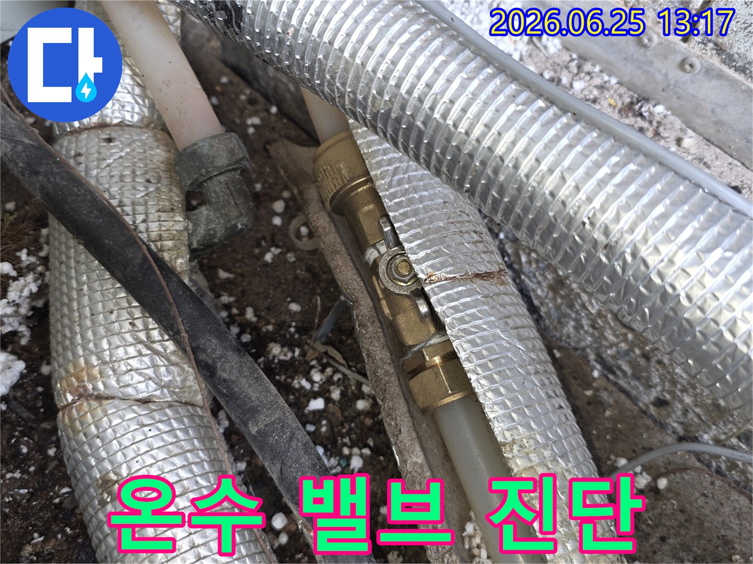 단열재로-덮인-온수-배관-사이에-위치한-밸브에서-누수-여부를-정밀하게-진단하는-전문가의-모습